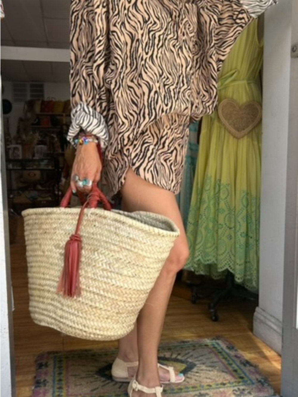 Woven Straw Tote with Red Tassel Handles.